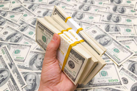 Hand holding american dollars against money background