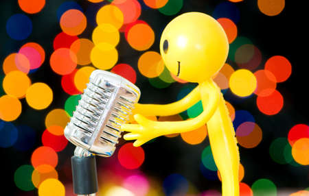 Vintage microphone and smilie against blurred lightsの写真素材