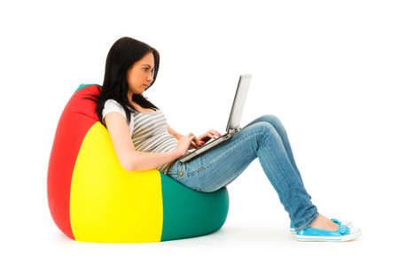 Girl working on laptop isolated on whiteの写真素材