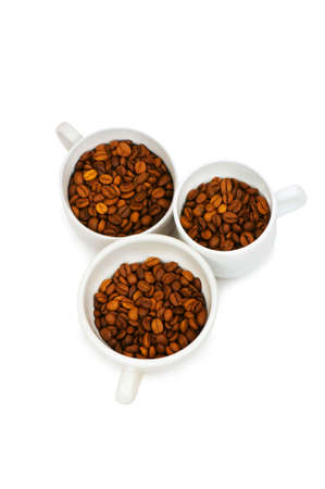 Three white cups full of coffee beansの写真素材