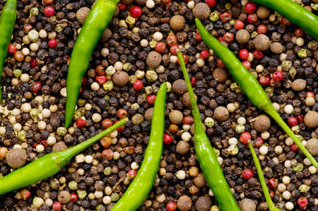 Red and green peppers on pepper backgroundの写真素材