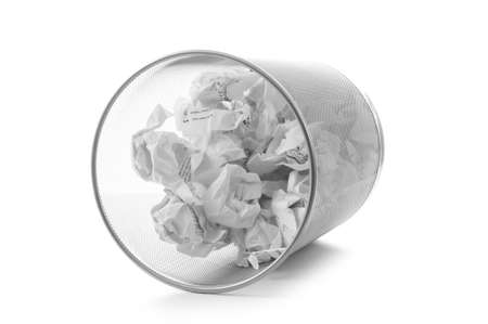 Garbage bin with paper waste isolated on whiteの写真素材
