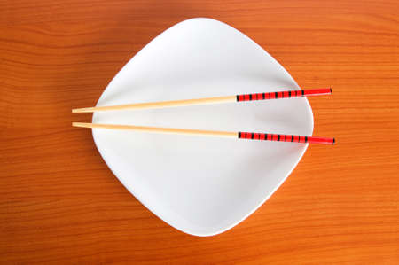 Plate with chopsticks on the wooden tableの写真素材