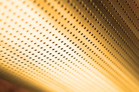Polished metal surface with the small holes の写真素材