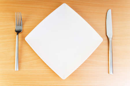 Plate with utensils on wooden table