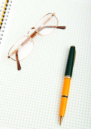 Pen and eye glasses on the pageの写真素材