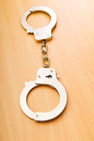 Metal handcuffs on the wooden backgroundの写真素材