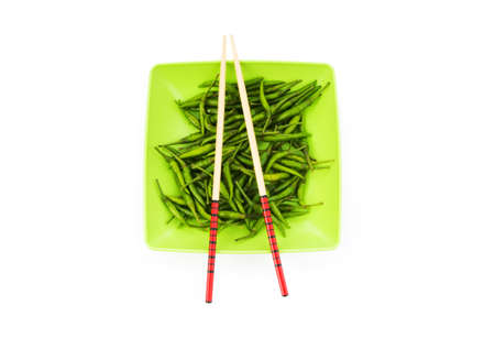 Hot peppers with chopsticks and plateの写真素材