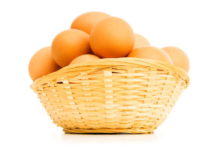 Brown eggs in the basket on whiteの写真素材