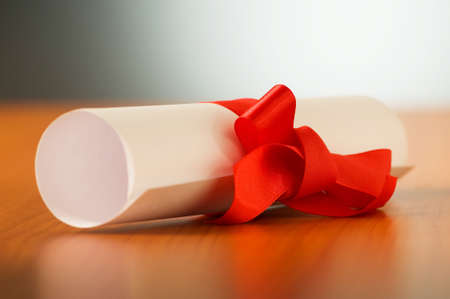Education concept - diploma roll on the wooden tableの写真素材