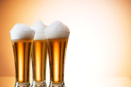 Beer glasses against the colorful gradient backgroundの写真素材