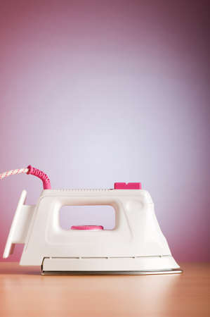 Modern electric iron against the colorful backgroundの写真素材