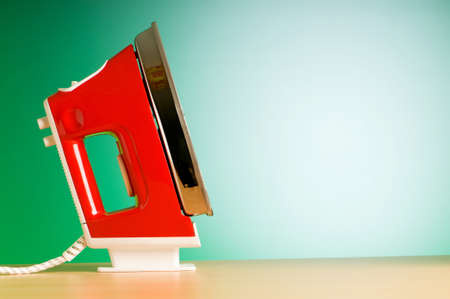 Modern electric iron against the colorful backgroundの写真素材