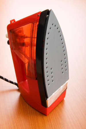 Modern electric iron on the wooden backgroundの写真素材