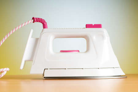 Modern electric iron against the colorful backgroundの写真素材