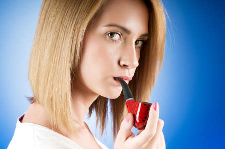 Girl smoking pipe against the gradient backgroundの写真素材