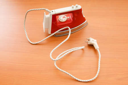Modern electric iron on the wooden backgroundの写真素材
