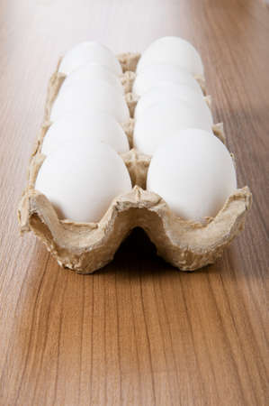 Many white eggs on the wooden table