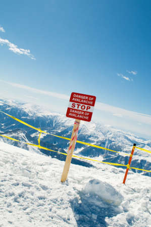 Avalanche sign and mountains at the backgroundの写真素材