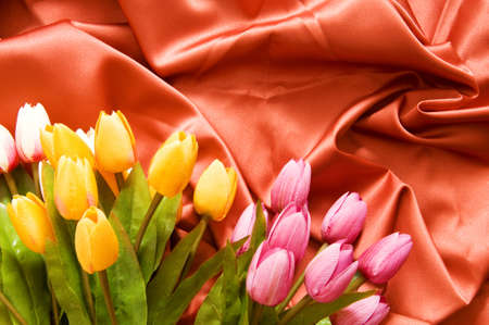 Many flowers on the red satin backgroundの写真素材