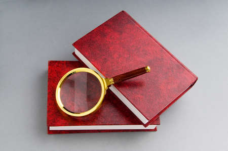 Magnifying glass over the stack of books の写真素材