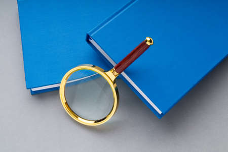 Magnifying glass over the stack of books の写真素材