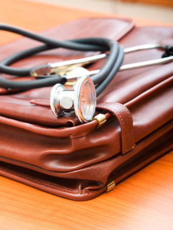 Doctor's case with stethoscope against wooden background の写真素材
