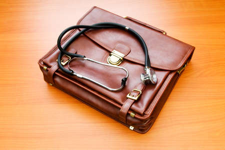 Doctor's case with stethoscope against wooden background の写真素材