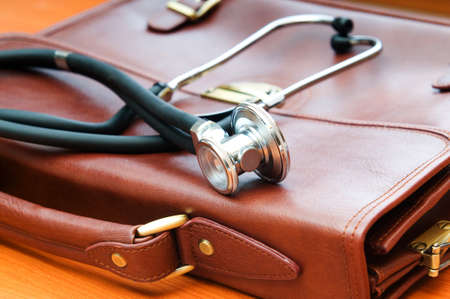 Doctor's case with stethoscope against wooden background の写真素材