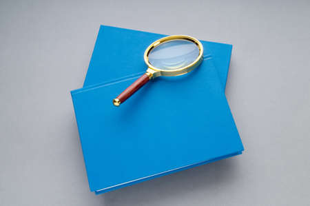Magnifying glass over the stack of books の写真素材