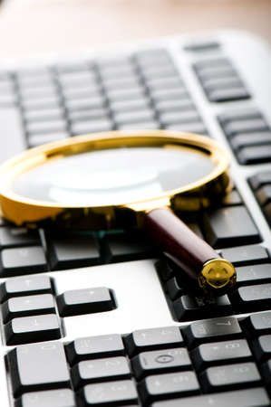 Computer security concept with keyboard and magnifying glassの写真素材