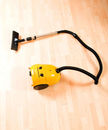 Vacuum cleaner on the polished wooden floor の写真素材