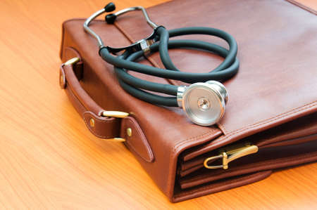 Doctor's case with stethoscope against wooden background の写真素材