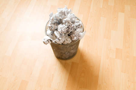 Garbage bin with paper waste isolated on white の写真素材