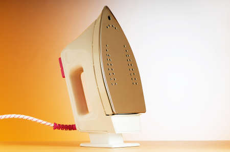 Modern electric iron against the colorful backgroundの写真素材