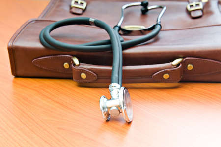 Doctor's case with stethoscope against wooden background の写真素材