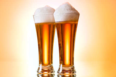Beer glasses against the colorful gradient backgroundの写真素材