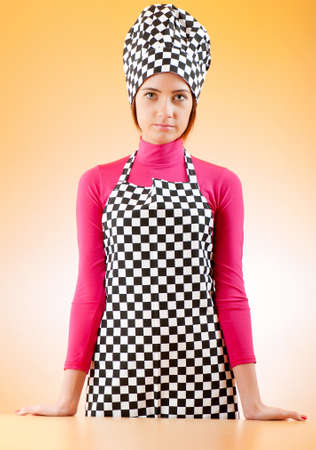 Young female cook against gradient backgroundの写真素材