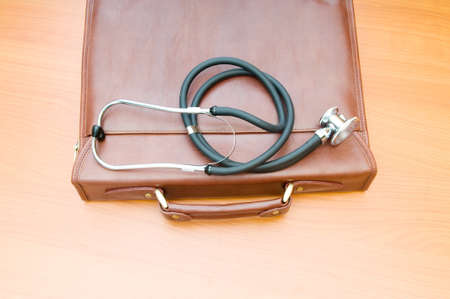Doctor's case with stethoscope against wooden background の写真素材