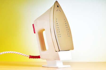 Modern electric iron against the colorful backgroundの写真素材