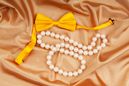 Bow ties and pearl necklace on the satinの写真素材