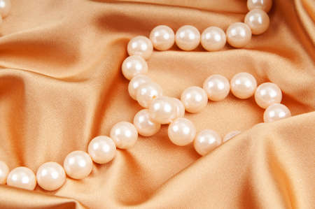 Pearl necklace on the bright satin backgroundの写真素材