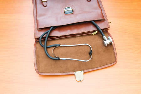 Doctor's case with stethoscope against wooden background の写真素材