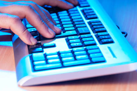 Two hands working on the silver keyboardの写真素材