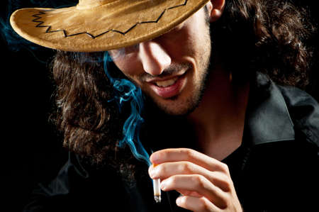 Man in cowbow hat smokingの写真素材