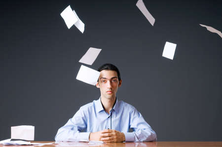 Flying paper and businessman in officeの写真素材