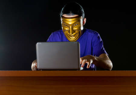 Hacker sitting in dark roomの写真素材