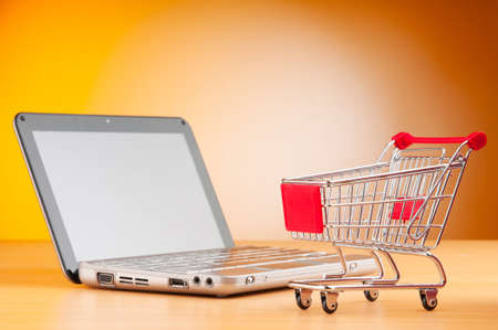 Shopping online with computer and cartの写真素材