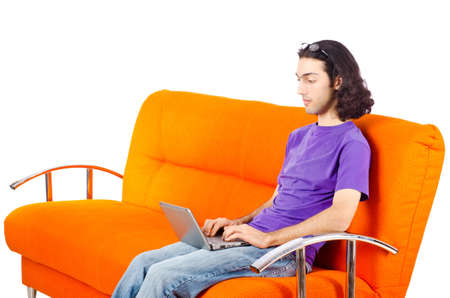 Student working with laptop sitting on sofaの写真素材