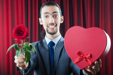 Young man with red roseの写真素材